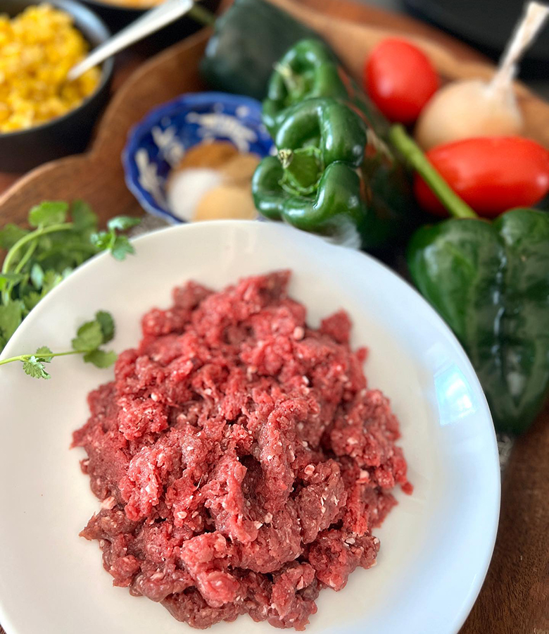 Elk stuffed poblano peppers with cornbread topping served with salsa and avocado