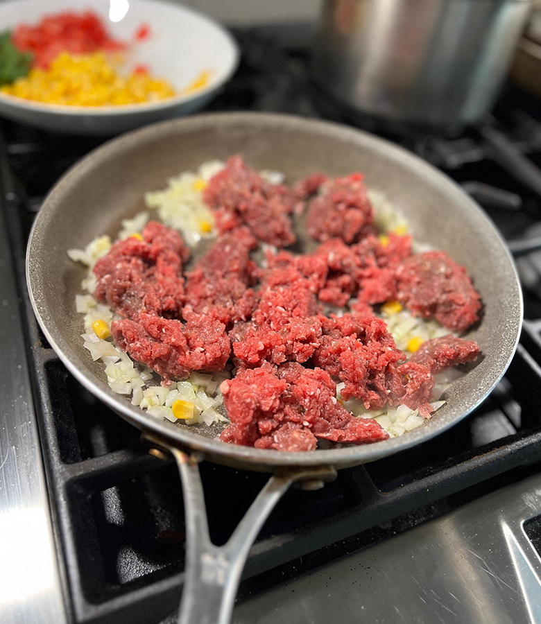 Elk stuffed poblano peppers with cornbread topping served with salsa and avocado