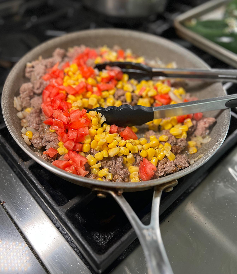 Elk stuffed poblano peppers with cornbread topping served with salsa and avocado