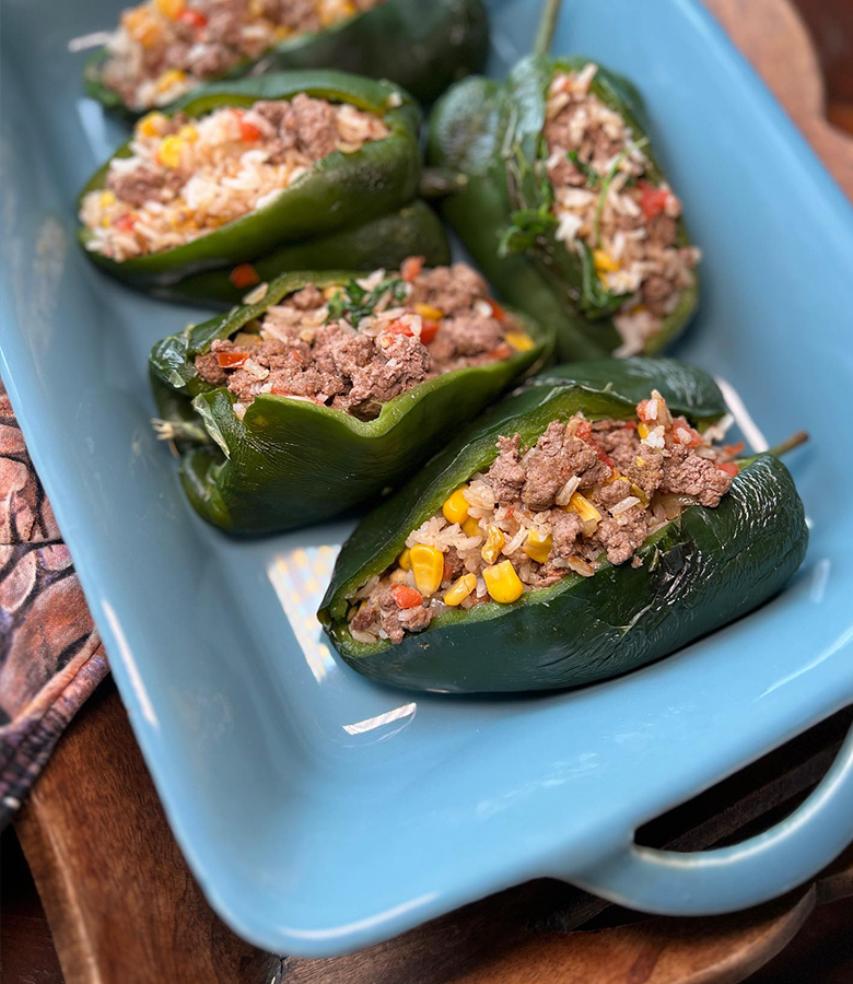 Elk stuffed poblano peppers with cornbread topping served with salsa and avocado