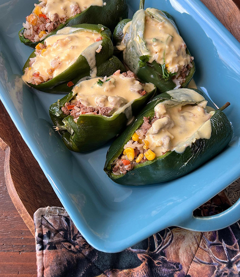 Elk stuffed poblano peppers with cornbread topping served with salsa and avocado